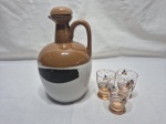 Garrafa vazia, botija em porcelana com 3 copos de shot em vidro. Medindo a garrafa 19cm de altura.