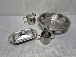 Lote diverso, composto de fruteira redonda, manteigueira, açucareiro sem tampa e leiteira, peças em aço inox. Medindo cesta 27cm x 6cm de altura.
