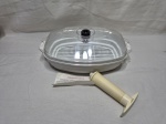Marinador a vácuo Epivac para micro-ondas composto por travessa plástica branca com grelha interna removível, tampa transparente com válvula reguladora preta, bomba manual extratora de ar e folheto informativo original de instruções. Medindo 28cm x 20cm x 7cm de altura.