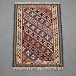 00610 - TAPETE KILIM PERSA KASHIGAY -  Manufatura em lã sobre lã. Tapete no estilo tribal apresenta composição integralmente geométrica, organizada por uma malha de losangos dispostos em sucessivas fileiras, preenchidos por motivos cruciformes estilizados em azul, marfim, rosa, verde, castanho e preto, sobre estrutura predominante em tons de vermelho e azul.A peça é enquadrada por múltiplas bordaduras geométricas, com guardas denticuladas e faixas escalonadas, mantendo forte regularidade gráfica e equilíbrio cromático.