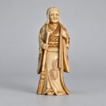 MARFIM  Escultura japonesa talhada em marfim, representando figura feminina em traje tradicional, segurando longa vassoura.Medindo 10 x 4,5 cm, apresenta vestes trabalhadas com decoração incisa de motivos geométricos e padrões japoneses, com detalhamento no obi, nas mangas e na parte inferior do quimono. A base conserva marca/assinatura incisa. Produção japonesa do período Meiji (18681912), final do século XIX/início do século XX, pertencente à tradição dos okimono em marfim.