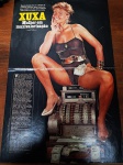 Reportagem Vintage Xuxa Meneghel  Revista Manchete (Anos 1980)  Raridade para Colecionadores Início da década de 1980 (Matéria celebra os 20 anos de idade de Xuxa).Conteúdo das Páginas (Frente e Verso):Página Principal: Foto de página dupla de Xuxa posando com maiô preto sobre uma caixa registradora antiga com cédulas de dinheiro. Título: "XUXA  Mulher em maxivalorização".Páginas do Verso: Ensaio fotográfico contínuo de página dupla. Traz uma grande foto de Xuxa na praia usando chapéu e colar de conchas, acompanhada de duas fotos menores (uma em estúdio de casaco e outra posando sorridente). O texto jornalístico traz uma entrevista íntima detalhando sua rotina de viagens internacionais (Berlim, Munique, Nova Iorque), bastidores de desfiles, hábitos alimentares da época e reflexões sobre o início precoce de sua fama aos 16 anos.