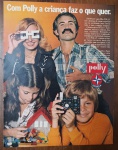 Propaganda Vintage Anos 70 Blocos De Montar Polly Estrela Revista OriginalFotografia clássica de época mostrando uma família (pais e dois filhos) interagindo com as criações feitas com os blocos Polly. Destaca-se a mãe usando óculos montados com os blocos, a filha montando uma casa com telhado vermelho e o filho segurando uma réplica de câmera fotográfica feita com as peças pretas e coloridas. No canto direito, aparecem os logotipos clássicos da Polly e da Estrela.