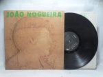Disco de Vinil LP - `Pelas Terras do Pau Brasil`, com João Nogueira, em bom estado. Inclui encarte.