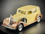 Miniatura Automóvel Clássico  Packard Sedan (Solido, Ref. 4047) / 1937 / Escala 1:43, fabricada em França pela prestigiada marca Solido, reproduzindo fielmente o icónico Packard Sedan de 1937. Apresenta carroçaria em tom bege/creme com guarda-lamas e estribos em acabamento acastanhado metalizado, portas laterais móveis/abrir, pneu sobressalente lateral, grelha frontal cromada de destaque com ornamento no capô e interior detalhado em tons de amarelo. Med. 04x13x04 cm. Marcas do tempo e de uso.