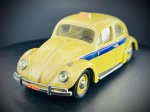 Miniatura Automóvel Clássico  Volkswagen Carocha Táxi (Escala 1:43), Apresenta carroçaria em tom amarelo com uma faixa decorativa lateral em azul, tejadilho equipado com luminoso de "Táxi", para-choques cromados com placas de matrícula detalhadas de época (Rio de Janeiro / Exp. 1950), jantes amarelas com tampas cromadas e chassis gravado de fabrico (Fabriqué en Chine). Med. 03x09x03 cm. Marcas do tempo e de uso.