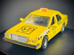 Miniatura Automóvel  Táxi de Nova Iorque (Yellow Cab / I Love NY), com portas laterais practicable (abertura funcional), interior detalhado, grelha frontal cromada e chassi inferior em plástico com representação mecânica em relevo. Med. 03x12x04 cm. Marcas do tempo e de uso.