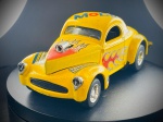 Miniatura Customizada  Willys 41 Hot Rod (Majorette), Carroçaria em tom amarelo vivo decorada com chamas vermelhas nas laterais e diversos autocolantes temáticos de marcas clássicas de competição e lubrificantes (Mobil, Castrol, STP, Champion, Goodyear, entre outros). O modelo conta com capô dianteiro removível que revela o motor pormenorizado com compressor proeminente, escapes laterais e jantes cromadas desportivas. Escala 1:43. Marcas do tempo e de uso.