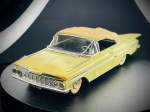 Miniatura Chevrolet Impala 1959 (Vitesse), escala 1:43, carroçaria em tom amarelo claro, capota de lona bege, acabamentos cromados destacados, pneus de banda branca e chapa de matrícula da Califórnia (DSJ 333). O modelo exibe na base a gravação de fabrico português da marca Vitesse. Marcas do tempo e de uso.