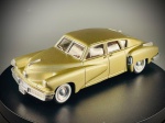 Miniatura Solido  Tucker 1948 (Escala 1:43), fabricada em França pela prestigiada marca Solido, reproduzindo com grande rigor o icónico e revolucionário Tucker 1948. ("Solido", "Made in France", além da identificação do modelo e escala "TUCKER 1948 - 1/43 0290"). A peça destaca-se pela sua distinta carroçaria em tom dourado/acobreado metalizado, complementada por interiores detalhados em tons de castanho e generosos frisos cromados. Conta com jantes clássicas equipadas com pneus de faixa branca e detalhes fiéis ao modelo original, incluindo o famoso farol central direcional. Marcas do tempo e de uso.