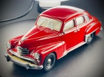 Miniatura Opel Kapitän (1951-1953) - Minichamps, com carroçaria em tom vermelho vivo, grelha frontal cromada de linhas clássicas, para-choques polidos com proteções, escovas do para-brisas detalhadas em relevo e interior em tons claros. O chassi inferior detalhado exibe a gravação oficial da marca Minichamps, o modelo e o período de fabrico. Med. 03x11x03 cm. Marcas do tempo e de uso.