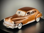 Miniatura Chrysler Windsor (1946)  Solido, apresentando carroçaria em tom acobreado metalizado, grelha frontal e para-choques cromados proeminentes, pneus de faixa branca com tampas de cubo decorativas e matrícula da Califórnia ("DMA 128"). A base inferior exibe com clareza as inscrições de fabrico da Solido, a escala 1:43 e a referência ao modelo de 1946. Marcas do tempo e de uso.