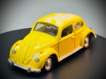Miniatura Volkswagen Carocha (Fusca), escala: 1:43, carroçaria e componentes metálicos, apresentando acabamento em tom amarelo vivo, para-choques, puxadores e frisos cromados, interior detalhado em tons acastanhados e rodas com tampas cromadas. Marcas do tempo e de uso.