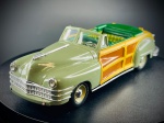 Miniatura Chrysler Town & Country  Vitesse (Escala 1:43), arroçaria em tom verde sálvia combinada com painéis laterais e traseiros detalhados com efeito de madeira. Interior minuciosamente trabalhado em tons de verde e estofos com padrão xadrez, capota recolhida simulada, para-choques e grelha frontal cromados, e matrícula decorativa traseira da Califórnia. Marcas do tempo e de uso.
