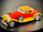 Miniatura em metal  Packard 1930 Boattail Speedster (Gusval), produzida em Espanha pela conceituada marca Gusval, replicando com charme o icónico Packard 1930 Boattail Speedster.   A peça apresenta uma marcante combinação de carroçaria em vermelho com guarda-lamas e estribos em tom amarelo, capota rígida removível/imitada em cor bege, além de detalhes clássicos como rodas raiada com pneus de faixa branca, pneus sobressalentes montados nas laterais e acabamentos metalizados. Med. 03x12x04 cm. Marcas do tempo e de uso.