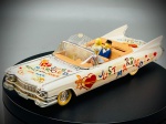 Miniatura Cadillac "Just Married" (Kathy and John)  Vitesse (Escala 1:43), Carroçaria descapotável em tom branco decorada com inscrições temáticas de casamento ("Just Married", "Kathy and John for ever", corações e laços), interior detalhado em tons claros com as figuras de um noivo e de uma noiva com véu, para-brisas em acetato com rebordo cromado, bem como elementos decorativos traseiros característicos da época. Marcas do tempo e de uso.
