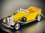 Miniatura Rolls-Royce Phantom II  Guisval, carroçaria em tom amarelo vivo com guarda-lamas e detalhes em preto, capota traseira recolhida em tons beges, interior detalhado com volante e assentos a condizer, faróis dianteiros cromados proeminentes e pneus sobressalentes montados lateralmente. Fabricado em Espanha (Made in Spain). Med. 03x12x04 cm. Marcas do tempo e de uso.