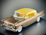 Miniatura Cadillac Eldorado Biarritz (1957)  Solido, carroçaria em tom castanho metalizado com tejadilho em amarelo contrastante, interior detalhado em tons amarelos e claros, acabamentos cromados de destaque (incluindo para-choques proeminentes, grelha frontal detalhada e emblemas da marca) e pneus de faixa branca clássicos. A base inferior exibe em relevo a marca Solido. Fabricado em França (Made in France). Escala 1:43. Marcas do tempo e do tempo.