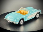 Miniatura 1960 Chevy Corvette  Ertl, carroçaria em tom azul-turquesa claro com painéis laterais em branco em contraste, interior detalhado em tons beges/amarelados, para-brisas envolvente com moldura cromada, grelha dianteira, para-choques e jantes detalhadas com acabamento metalizado. Escala 1:43. Marcas do tempo do tempo e de uso.