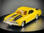 Miniatura 1969 Camaro Z/28  Ertl, carroçaria em tom amarelo vivo com riscas desportivas pretas duplas no capô e na bagageira, vidros fumados/âmbar, grelha frontal e para-choques detalhados com acabamento metalizado prateado. A base inferior exibe em relevo a marca Ertl. Med. 04x11x04 cm. Marcas do tempo e de uso.