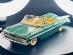 Miniatura Chevrolet Impala 1959  Vitesse, escala 1:43, Carroçaria em tom verde metalizado com interior em cor creme, grelha frontal e para-choques detalhados com acabamento metalizado prateado, e matrícula traseira da Califórnia (VIT 390). Marcas do tempo e de uso.
