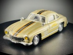 Miniatura em metal  Mercedes-Benz 300 SL (1954), produzida em França pela conceituada marca Solido, reproduzindo o icónico desportivo Mercedes-Benz 300 SL de 1954 (famoso pelas suas portas de abertura "asa de gaivota").   A peça apresenta uma distinta pintura em tom dourado com faixas decorativas centrais em preto e laranja, faróis dianteiros com lentes amarelas e portas funcionais com abertura vertical tipo asa de gaivota. Escala 1:43. Marcas do tempo e de uso.