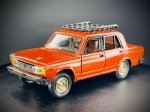 Miniatura Lada VAZ-2105  Made in USSR, escala 1:43, Carroçaria com acabamento detalhado, interior em tons contrastantes, volante e tablier modelados, e jantes douradas com pneus de borracha. O modelo dispõe de elementos móveis operacionais, nomeadamente as portas laterais e a tampa do compartimento do motor (capô) que revela o bloco detalhado. A base inferior exibe em relevo as inscrições BAZ-2105, a escala 1:43 e a origem MADE in USSR. Marcas do tempo e de uso.