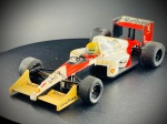 Miniatura McLaren MP4/5 (Fórmula 1)  Onyx, escala 1:43. McLaren MP4/5 (Monolugar de Fórmula 1 com motor Honda, pilotado pelo tricampeão mundial Ayrton Senna, ostentando o número de campeão "1", a icónica decoração em vermelho e branco e os patrocínios clássicos, incluindo a marca de tabaco, Shell e Goodyear). Marcas do tempo e de uso.