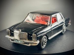 Miniatura Mercedes-Benz 240 D  Kiko, Mercedes-Benz 240 D (Série W115), icónica berlina clássica executiva em tom preto brilhante, com grelha frontal cromada encimada pela estrela da marca, para-choques metalizados, matrículas decorativas europeias (com a inscrição "GG:PV 308") e interior detalhado em cor vermelha viva. Med. 03x13x05 cm. Marcas do tempo e de uso.
