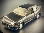 Miniatura Chevrolet Kadett GS, icônico desportivo de três portas em tom escuro metalizado, equipado com tejadilho em cor contrastante, aileron traseiro desportivo, placa de matrícula decorativa com a inscrição "KADETT GS", grelha frontal detalhada com o emblema da gravata Chevrolet e jantes desportivas de época. Med. 04x12x04 cm. Marcas do tempo e de uso.