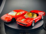 Miniaturas Ferrari (308 GTS e Testarossa), Ferrari 308 GTS: Versão descapotável targa em tom vermelho clássico, fabricada pela Corgi (Made in Great Britain), com decoração com faixas tricolores e emblema no capô, faróis escamoteáveis abertos, interior em tons claros e tampa do motor traseira funcional/aberta revelando os detalhes mecânicos.   Ferrari Testarossa: Icónico supercarro desportivo em tom vermelho, fabricado pela Bburago na Itália, com as caraterísticas entradas de ar laterais em riscas, tejadilho coupé fechado, jantes desportivas e interior detalhado. Med. 03x10x04 cm e 03x12x05 cm. Marcas do tempo e de uso.
