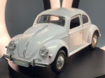 Miniatura Volkswagen Carocha (Beetle), Automóvel clássico Volkswagen Carocha em tom claro metalizado, equipado com portas dianteiras móveis e articuladas, interior detalhado com bancos pretos, tablier completo e volante texturado. com acabamentos cromados nos para-choques, faróis e molduras, apresentando chapa de matrícula frontal e traseira com a inscrição "SS9407" e gravuras na base com a marca oficial "VOLKSWAGEN". Med. 05x16x08 cm. Marcas do tempo e de uso.