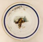 Prato em porcelana Schmidt, decorado com cena de casa em neve, porcelana em ótimo estado, mas com desgastes do tempo na pintura. Med. Diâm. 24,5 cm.