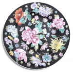 Prato decorativo em porcelana oriental, com fundo preto e rica decoração floral policromada em esmaltes coloridos, destacando peônias, crisântemos e outras flores em delicada composição. Peça de grande efeito ornamental, marcada na base Made in China  For Decorative Use, ideal para decoração de parede ou coleção. Mede 23cm de diâmetro.