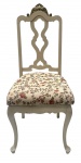 Cadeira de estilo clássico europeu, em madeira patinada em tom claro, com encosto vazado de linhas curvas e elemento decorativo superior dourado. Assento estofado em tecido floral, conferindo charme e delicadeza à peça. Pernas curvas, de inspiração francesa, ideal para compor salas, quartos ou ambientes românticos e elegantes.Sinal de restauro no topo. Mede 1,10 cm altura.