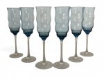 Conjunto com seis taças em vidro artístico, bojo em tom azul claro levemente ondulado, hastes longas transparentes e base circular. Vidro soprado, com pequenas variações naturais da fabricação manual, conjunto elegante e delicado, ideal para espumantes ou uso decorativo. Mede 25 cm altura.