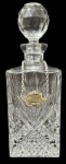 Decanter para Whisky em cristal lapidado, corpo facetado com rico trabalho geométrico, tampa original lapidada, acompanhado de plaqueta metálica Whisky presa por corrente. Peça elegante, de mesa ou bar, com selo antigo do fabricante, indicando produção francesa. Bom estado geral, com marcas compatíveis com a idade. Mede 28cm de altura.