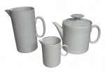 Conjunto para café em porcelana brasileira, composto por bule com tampa, leiteira e cremeira, em elegante tonalidade branco gelo com delicado friso prateado na borda e decoração floral em relevo discreto. Peças de linhas modernas e funcionais, marcadas na base Porcelana Renner  Porto Alegre, tradicional manufatura nacional. Em bom estado de conservação, apresentando sinais compatíveis com o uso e o tempo. Medida da maior 15X17cm.