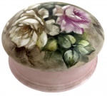 Caixa porta-joias em porcelana esmaltada, tampa e interior com pintura floral policromada, assinada Dolila  Guanabara. Mede 16 cm diâmetro.