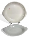 Par de travessas em porcelana branca, sendo uma circular com alças laterais e outra oval, marca Arealp Porcelain. Peças de linhas simples e elegantes, com leve desgaste compatível com o uso. Medida da maior 25cm.