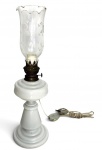 Luminária antiga de mesa, base em opalina branca com corpo em metal patinado e cúpula em cristal translúcido decorado com delicados motivos florais. Sistema originalmente a querosene, posteriormente adaptado para eletrificação. Peça elegante, de caráter decorativo clássico. Mede 47cm de altura.