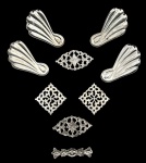 Conjunto de apliques ornamentais em metal prateado, composto por elementos vazados de inspiração clássica e quatro peças em formato de concha. Ricos em detalhes, ideais para restauro de arte sacra ou aplicação decorativa. Medida do maior 7cm.