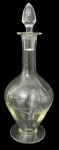 Garrafa licoreira antiga em cristal, corpo bojudo com leve tonalidade esverdeada, decorada com delicados motivos florais gravados. Gargalo alongado com tampa original lapidada. Peça elegante de uso decorativo ou serviço. Mede 32cm.