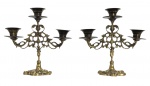 Par de castiçais para três velas, em metal espessado a bronze, com elegante decoração vazada em estilo art nouveau, apresentando base recortada e braços sinuosos. Peças de forte apelo decorativo e clássico acabamento patinado. Mede 23cm x 23cm.