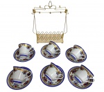 Conjunto com 6 xícaras para café em porcelana Germer, acompanhadas de pires e suporte metálico dourado. Peças com rica decoração floral policromada, detalhes em douração e bordas em azul cobalto. Marca Germer na base. Pintadas a mão. Acompanham seus pires.