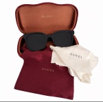 GUCCI - Óculos de sol Gucci com armação em acetato preto e lentes escuras, acompanhado de estojo original rígido com proteção em veludo vermelho, saquinho protetor e flanela da marca. Peça de design elegante e atemporal, em ótimo estado de conservação. Inscrições da marca em dourado. Trazido da Italia. Medida do estojo 18 cm.