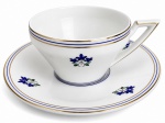 PORTUGAL CANDAL  Xícara para chá com pires em porcelana, decorada com delicados motivos florais em tons de azul e verde sobre fundo branco. Bordas ornamentadas por filetes azuis e dourados, destacando o refinamento da manufatura portuguesa. Design geométrico Art Déco. Na base, marca da tradicional fábrica portuguesa Candal, importante produtora de porcelanas e faianças do século XX. Peça elegante para uso ou coleção, representativa da produção portuguesa de mesa e chá.