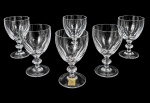 STRAUSS - Conjunto com 6 taças para vinho em cristal Strauss translúcido, corpo liso com delicado trabalho lapidado na base e haste facetada. Peças elegantes, ideais para compor mesa refinada. Uma possui discreto bicado. Possuem selo. Medem 12,5 cm de altura.