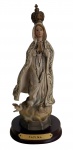 Nossa Senhora de Fátima  Escultura religiosa em resina policromada, representando a Virgem em posição orante, com rosário, coroa metálica e base em madeira com plaqueta identificadora Fátima. Rica em detalhes decorativos no manto e apoiada sobre nuvens com pombas. Medidas: 22 cm de altura.