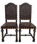PAR DE CADEIRAS EM ESTILO MANUELINO, em madeira escura, com rica decoração entalhada, motivos ornamentais, tachas metálicas e pernas torneadas em espiral, de inspiração portuguesa. Assento e encosto em couro pirogravado com marcas do tempo. Estrutura firme. Período provável: final do século XIX / início do XX.Medidas: 105 cm de altura x 44 cm de largura.